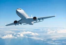 Avion survolant les nuages, illustrant l'accueil et le transfert aéroport proposés par La Kaz Mangococo